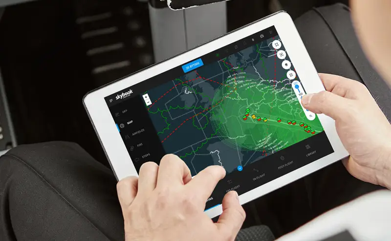 pilot in cockpit with weather briefing map on electronic flight bag